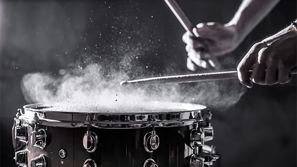 man plays musical percussion instrument with sticks, a musical concept, beautiful lighting on the stage